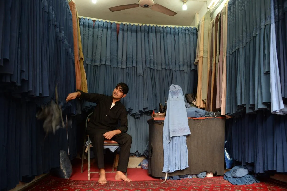 A shopkeeper selling burqas in his shop in Kabul, Afghanistan.